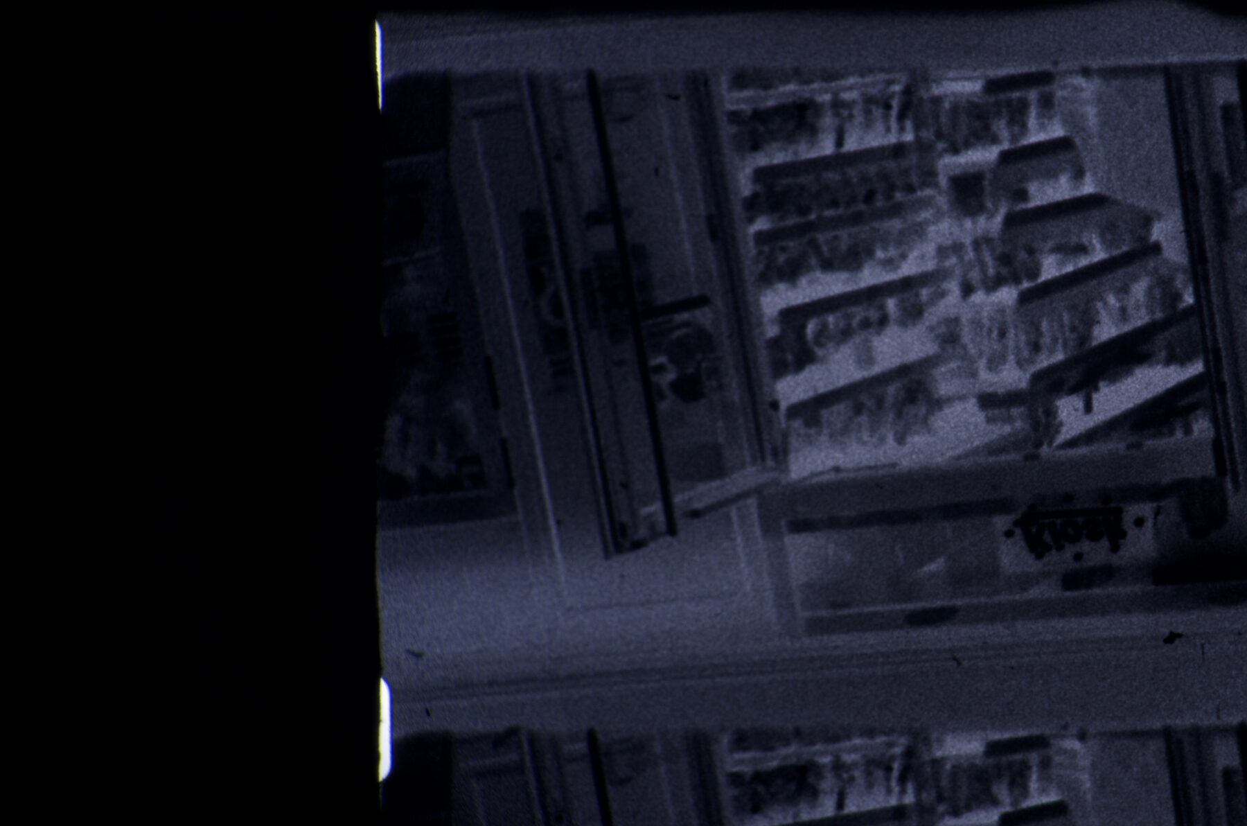 Blue-toned 16mm frame of a high-rise building at an angle