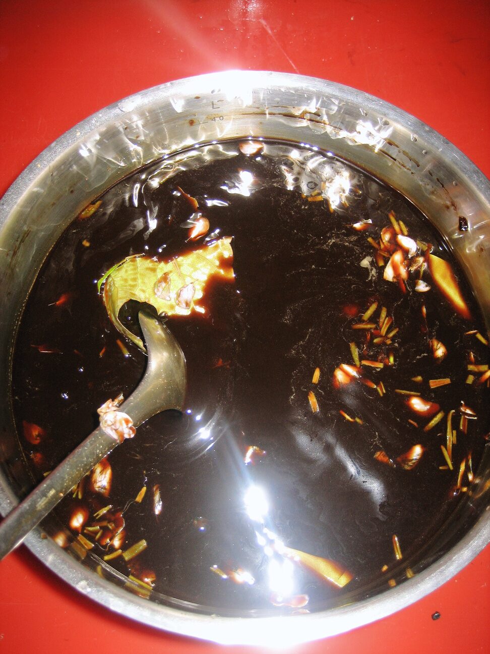 16mm film developing in a dark coffee-based developer, stirred with a ladle